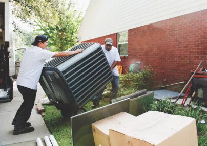 Technicians moving a new AC unit into place.